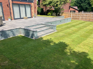We created a new patio area using Marshall’s Fairstone Granite Eclipse. The steps and walls were faced with Marshalls Stoneface Drystack veneer.